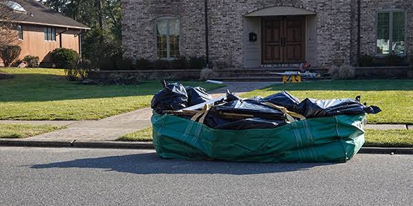 Filled waste bag near the curb outside a home
